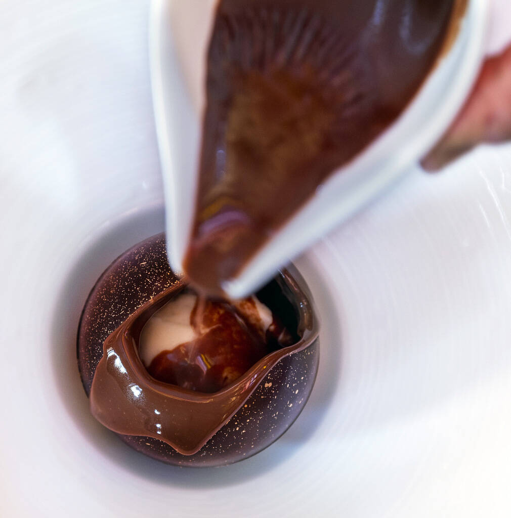 A chocolate ball with crème fraîche ice cream at Le Cirque restaurant within the Bellagio on ...