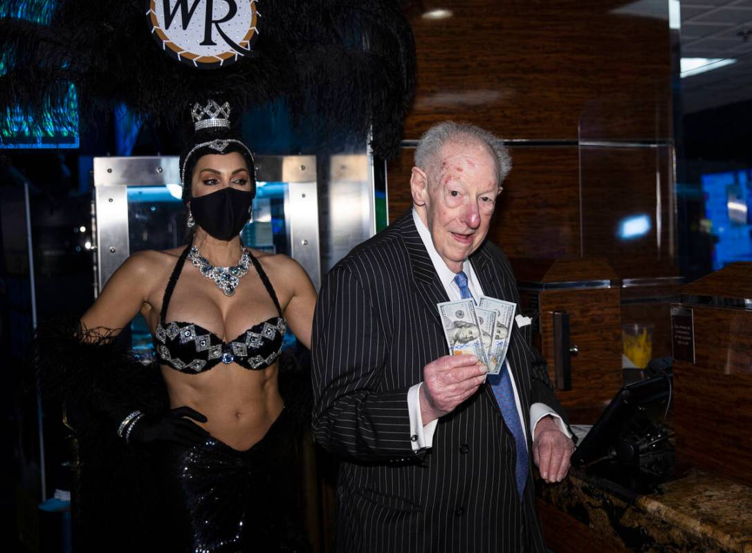 Former Las Vegas Mayor Oscar Goodman flashes dollar bills as he places his March Madness wager ...