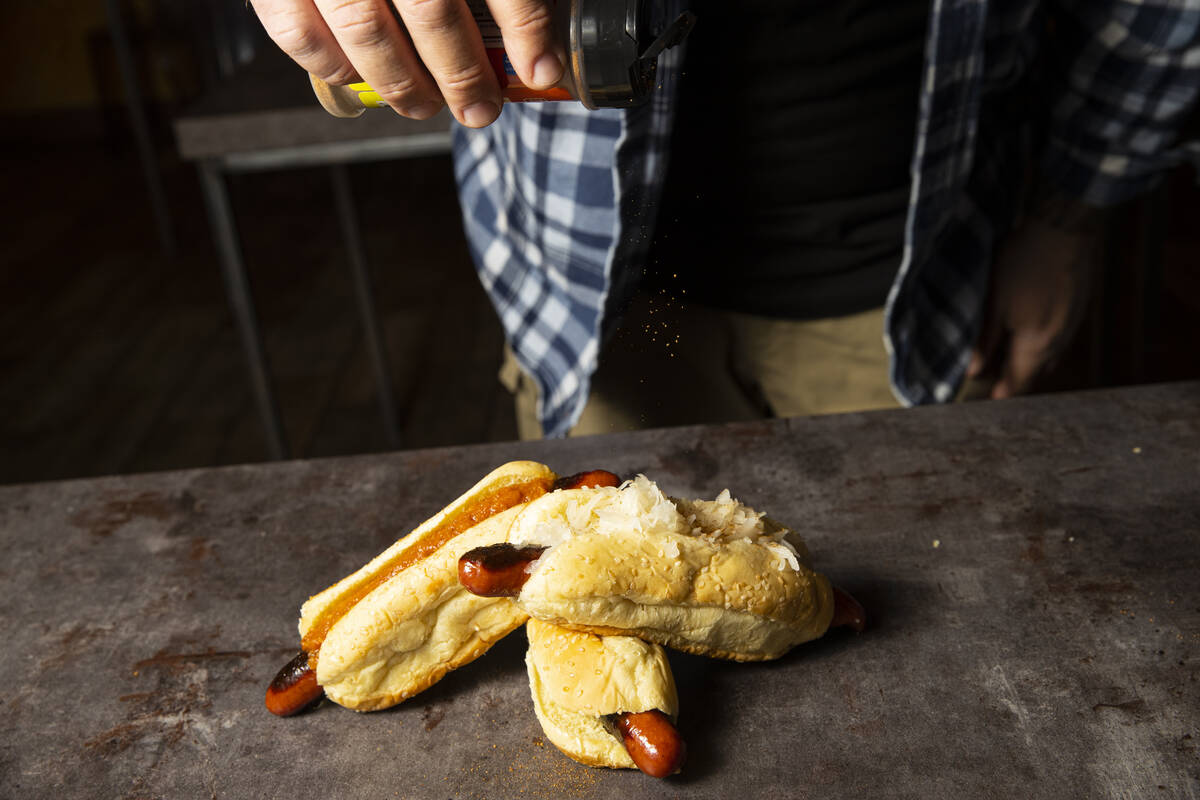 Ralph Perrazzo, founder of Snap-O-Razzo, adds his branded seasoning on Snap-O-Razzo hot dogs on ...