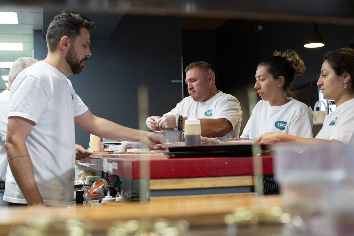 Jerad Howard, left, and Trent Jones, two members of the Dinette team, work with staff to prepar ...
