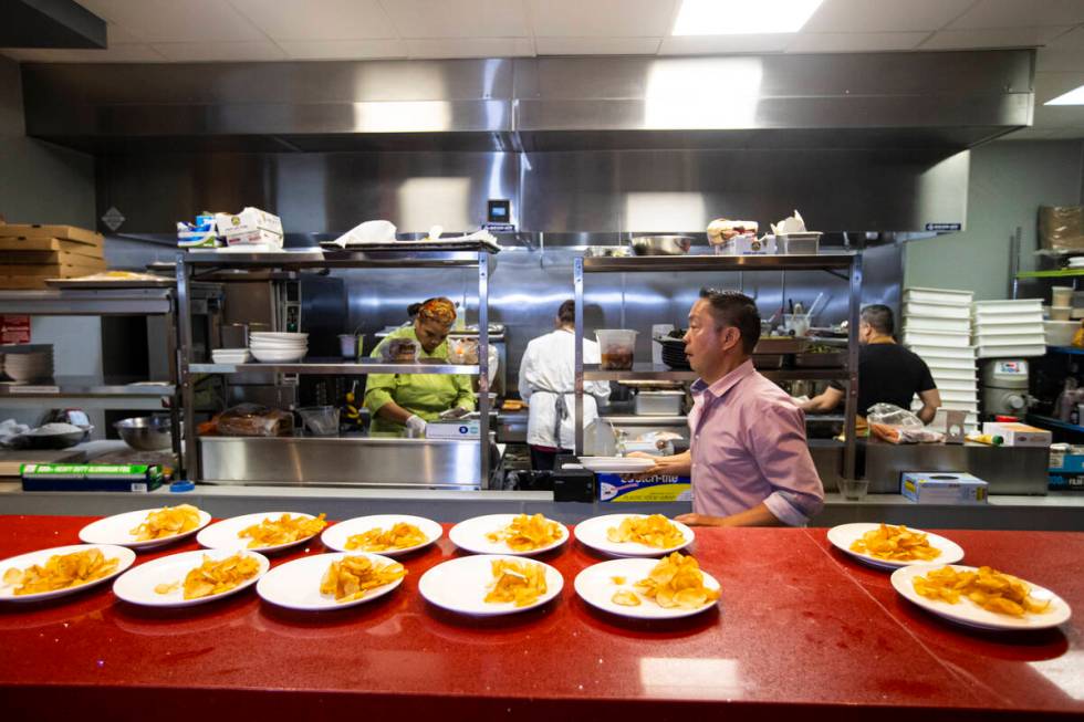 Luis De Santos, owner-operator of the Random Act Diner concept, center right, helps prepare dis ...