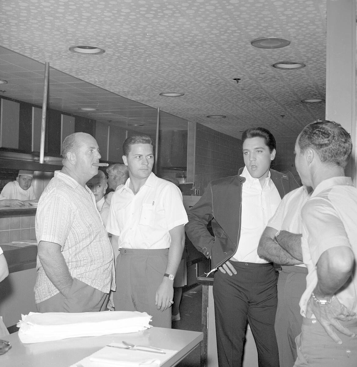 Elvis Presley and Colonel Tom Parker (with cigar) sign autographs and mingle with guests at the ...