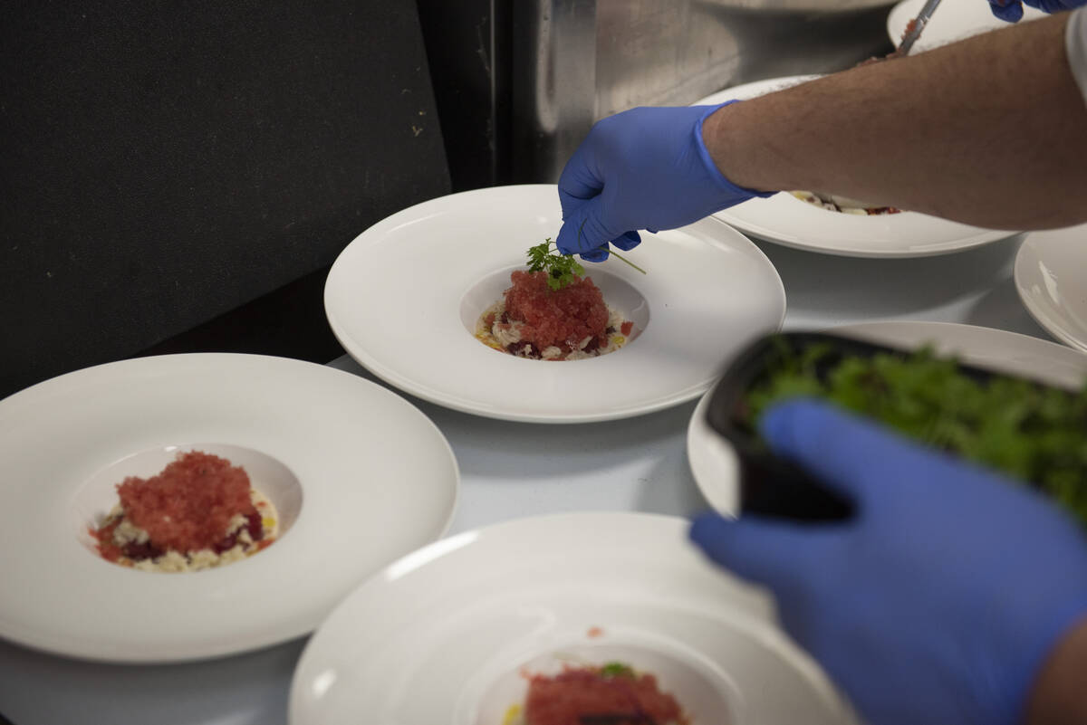 Chef Jeffrey Weiss garnishes the first dish, a tuna tartare with crab, watermelon granita, and ...
