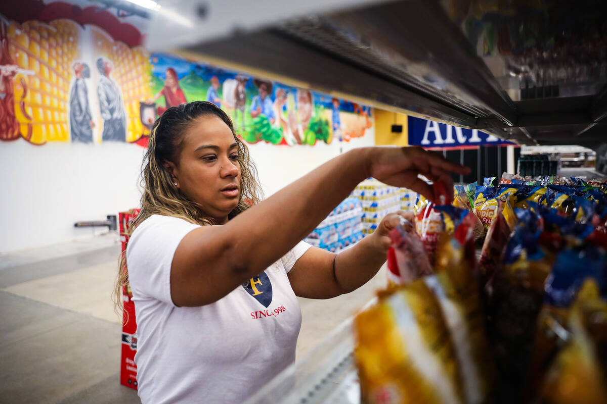 Co-owner Jinelle Batista restocks items at the gourmet food store Artisanal Foods in Las Vegas, ...