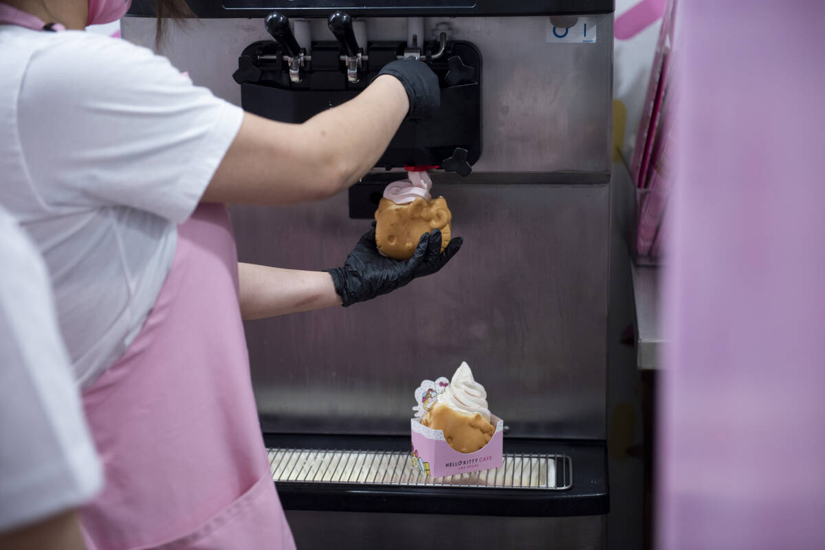 and employee pours the ice cream for the cafe's signature treat, soft served ice cream inside a ...