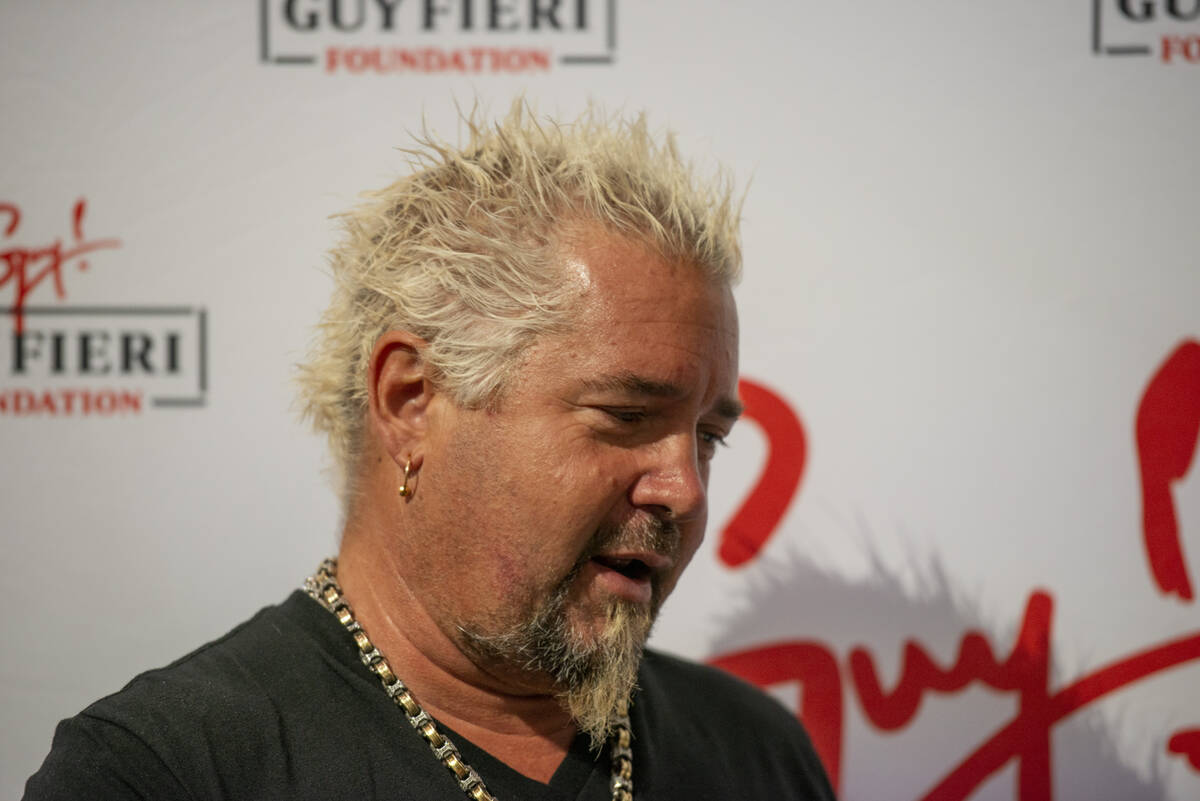 Chef and TV personality Guy Fieri talks to the media during an event honoring veterans and firs ...