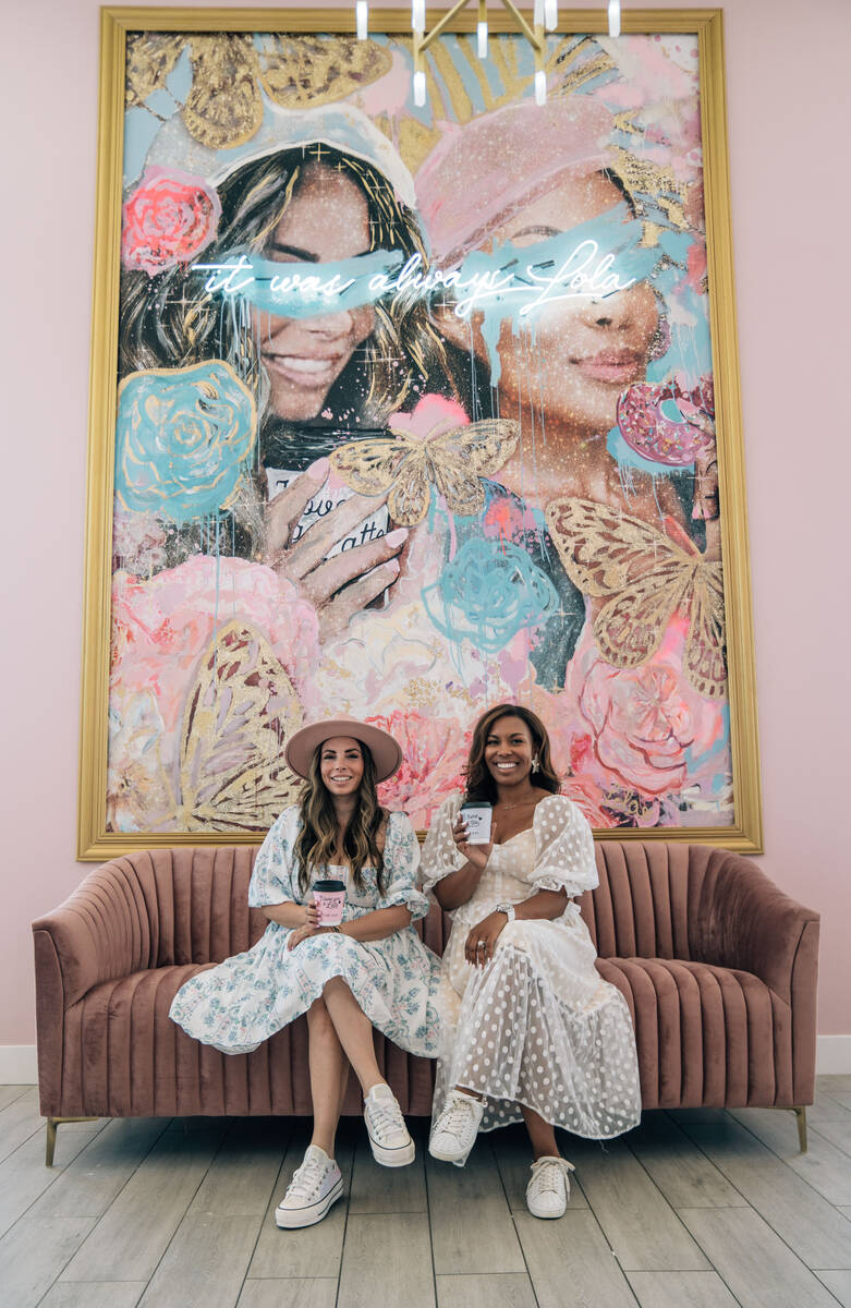 Alexandra Lourdes, left, and Lin Jerome, owner of the Café Lolas, take a moment beneath their ...