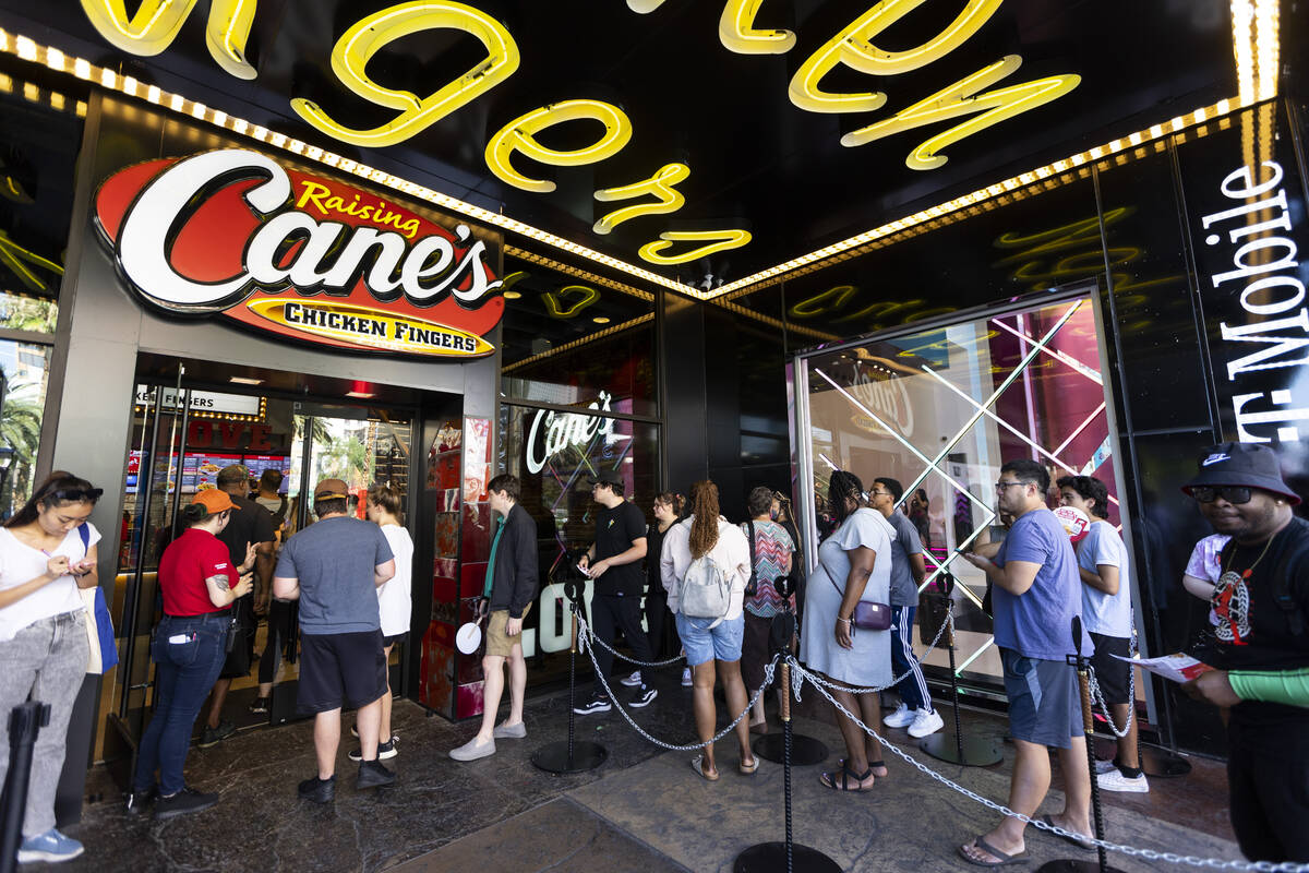 People attend the grand opening of the Raising Cane’s restaurant in the Showcase Mall in ...