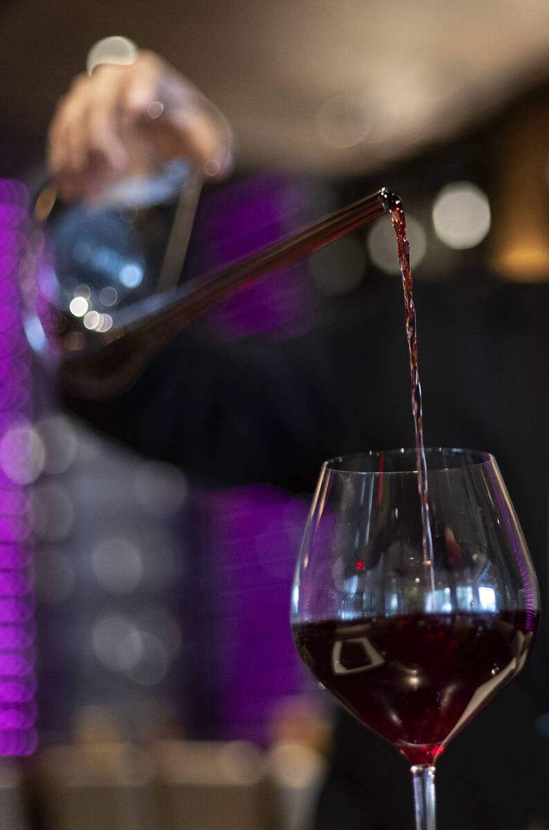 Sommelier Erick Ramirez pours wine from a decanter at La Cave Wine and Food Hideaway in Wynn La ...