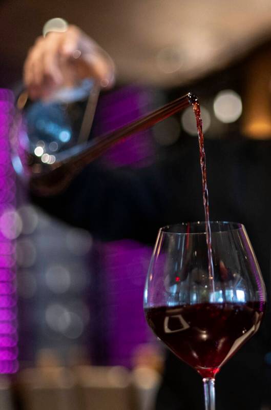 Sommelier Erick Ramirez pours wine from a decanter at La Cave Wine and Food Hideaway in Wynn La ...