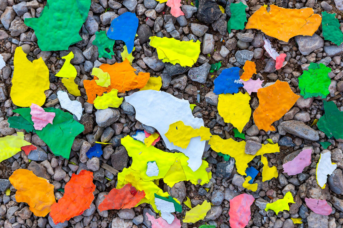 Colored paint chips gather at Seven Magic Mountains having been pressure-washed off as the art ...