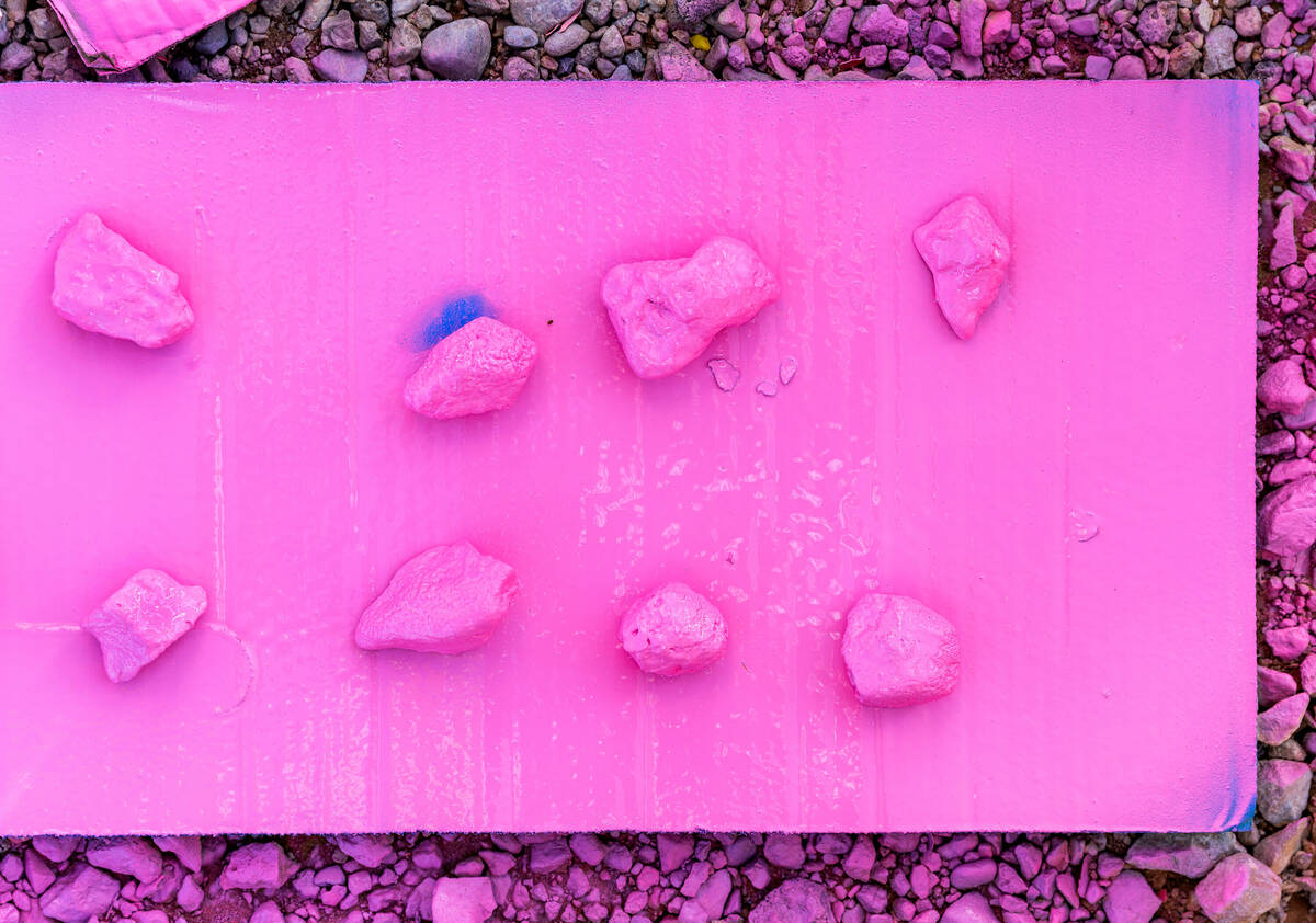 Test rocks for a pink base coat are sprayed at Seven Magic Mountains as the art installation un ...