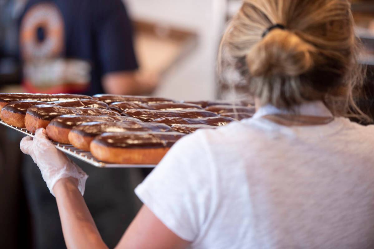 An employee brings out a fresh batch of doughnuts at Randy's Donuts on South Rainbow Boulevard ...
