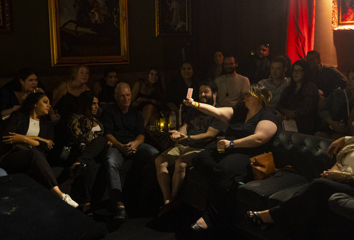 Leah Friedman, of San Francisco, holds up a card as The Magician, not pictured, of The Magician ...