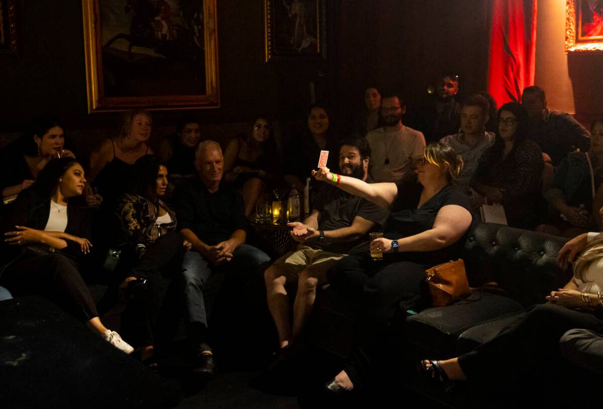 Leah Friedman, of San Francisco, holds up a card as The Magician, not pictured, of The Magician ...
