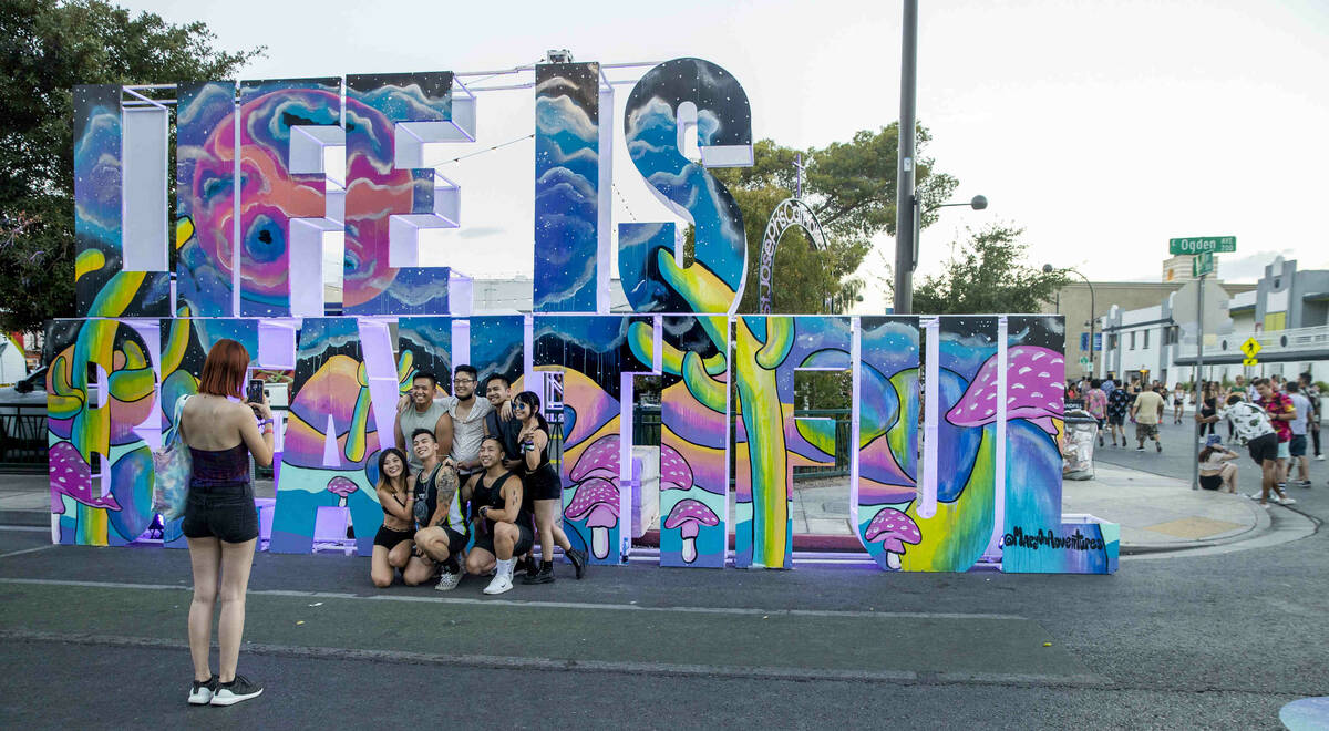 Friends gather about a sculpture along East Ogden Avenue during day one of Life is Beautiful on ...