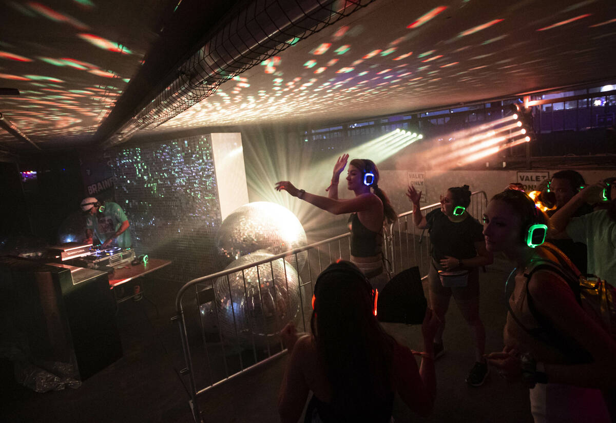 Attendees dance as Wizdumb performs in a silent disco at the 7-Eleven Brainfreeze Garage during ...