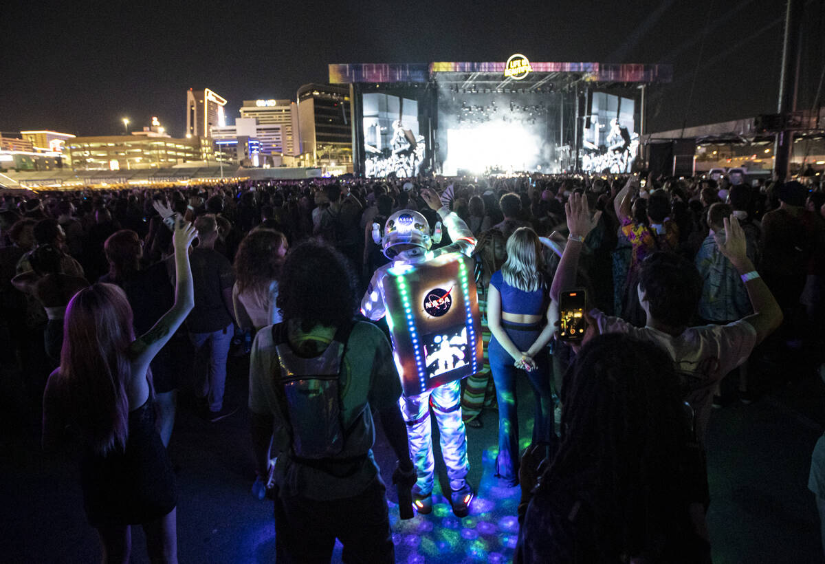 An attendee dressed up in a space suit cheers as Cage the Elephant performs during the first da ...