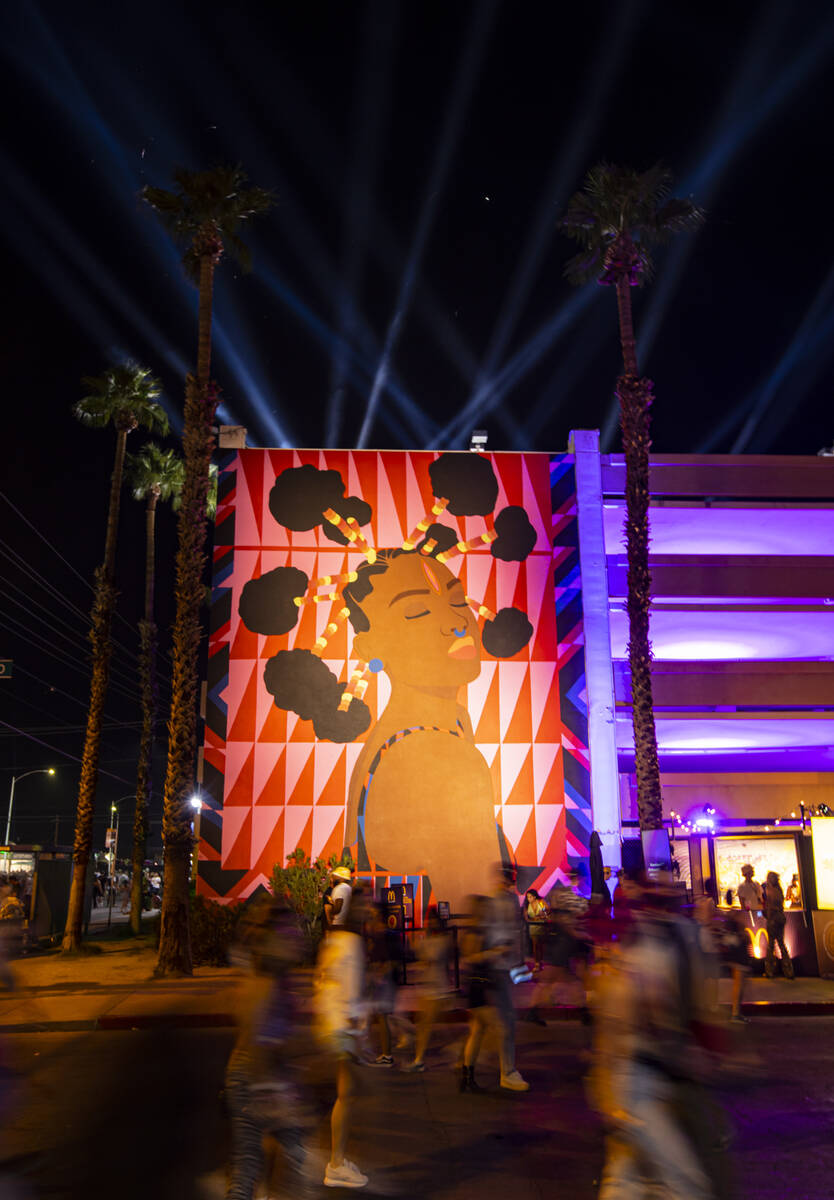 Attendees walk by a mural during the first day of the Life is Beautiful festival on Friday, Sep ...