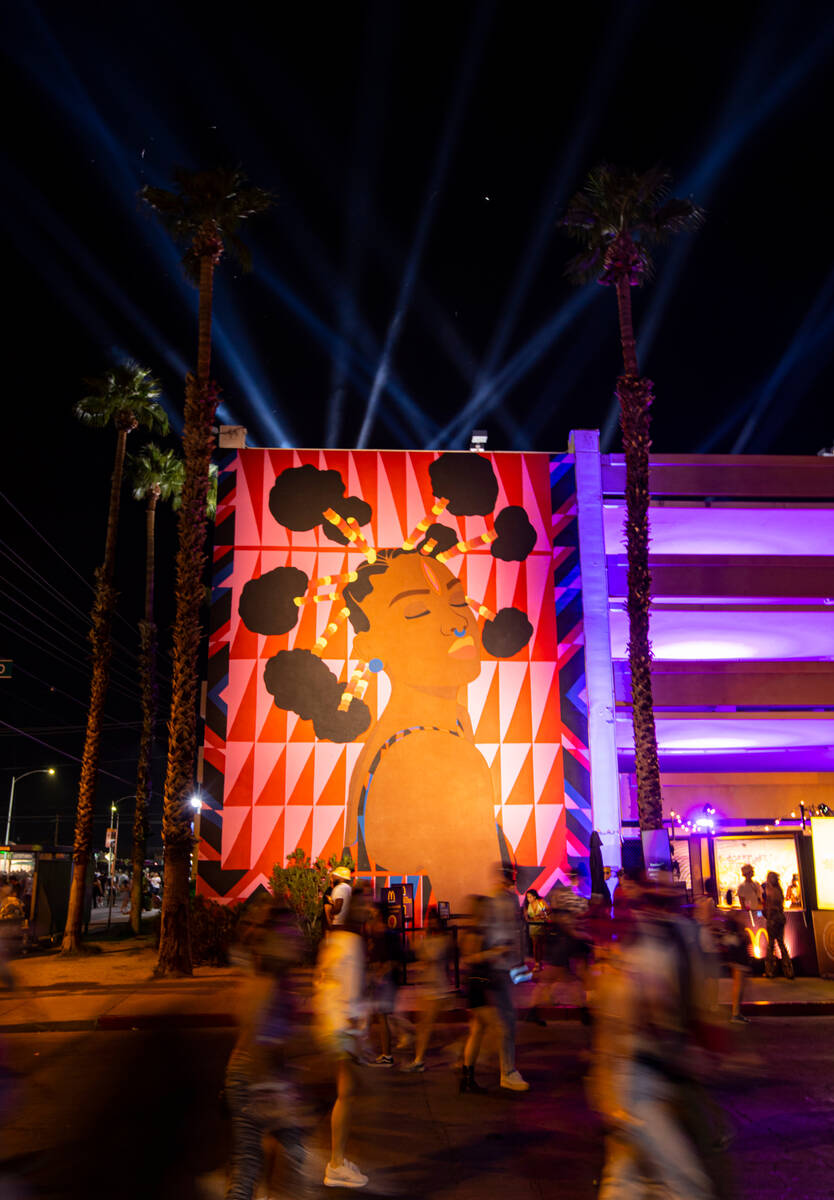 Attendees walk by a mural during the first day of the Life is Beautiful festival on Friday, Sep ...