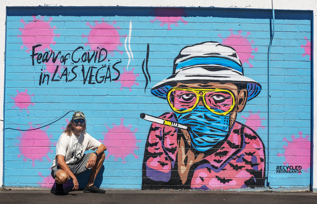Izaac Zevalking, owner and artist at Recycled Propaganda, stands in front of a mural he painted ...