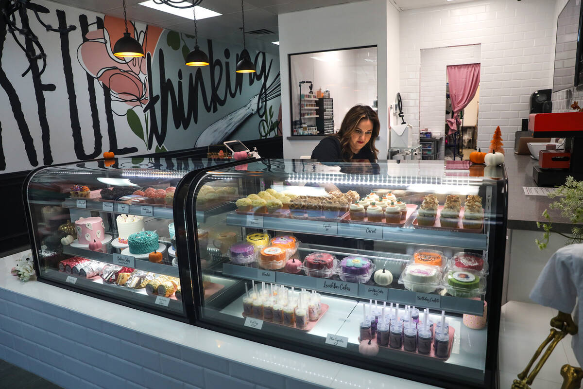 Co-owner Korey Wells sets out fresh cupcakes in the pastry case at Whiskful Thinking Cakes in L ...