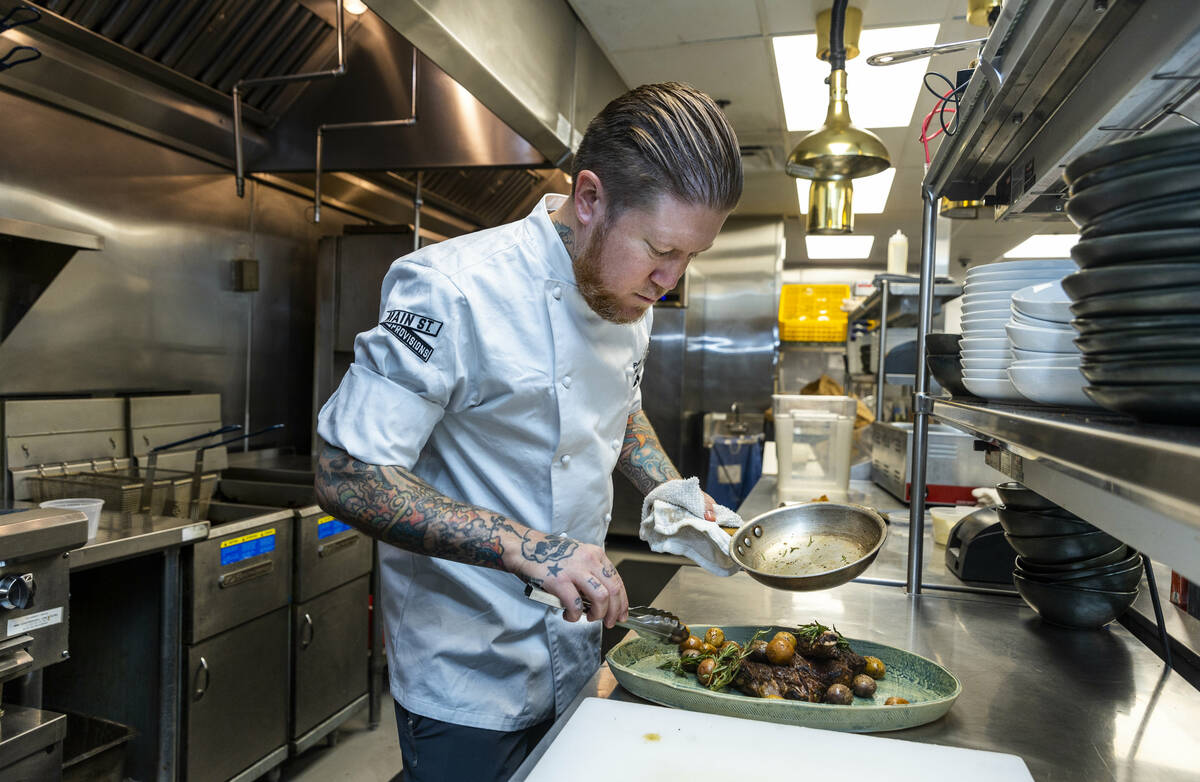 Main St. Provisions chef Patrick Munster prepares a double cut bone-in ribeye on Thursday, Oct. ...