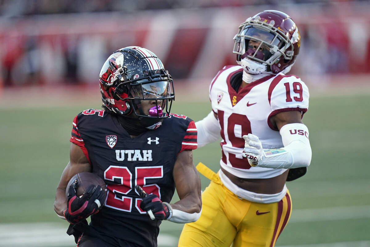 Utah wide receiver Jaylen Dixon (25) carries the ball past Southern California defensive back J ...