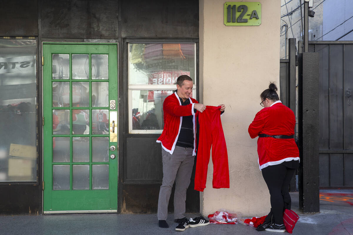 Josef Nagele, left, and Amanda Nagele suit up for The Las Vegas Great Santa Run at Fremont Stre ...