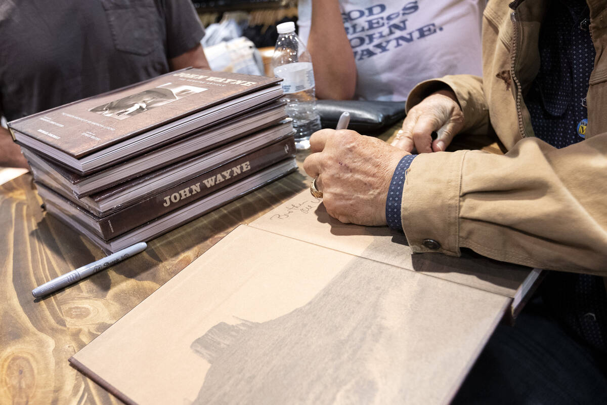 Marisa Wayne, John Wayne’s daughter, and her brother Patrick Wayne, right, sign one of t ...
