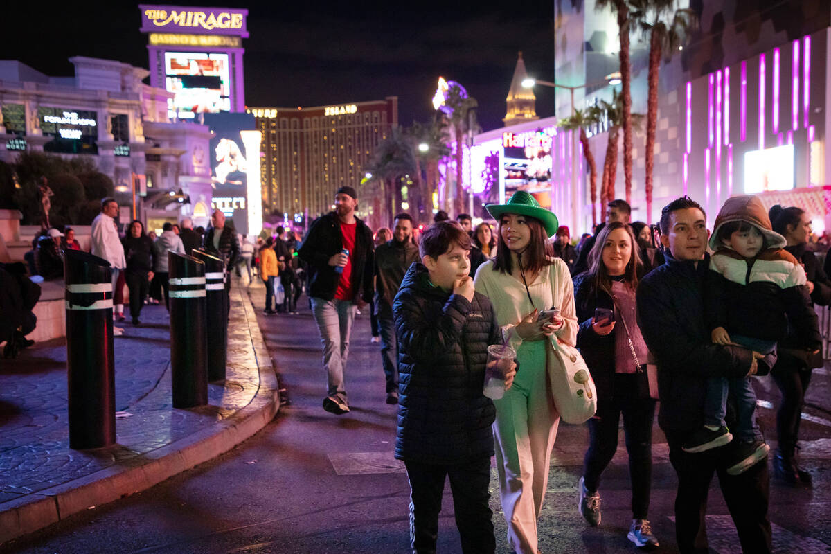 New Year’s Eve revelers walk down the Strip on Saturday, Dec. 31, 2022, in Las Vegas. (Amaya ...