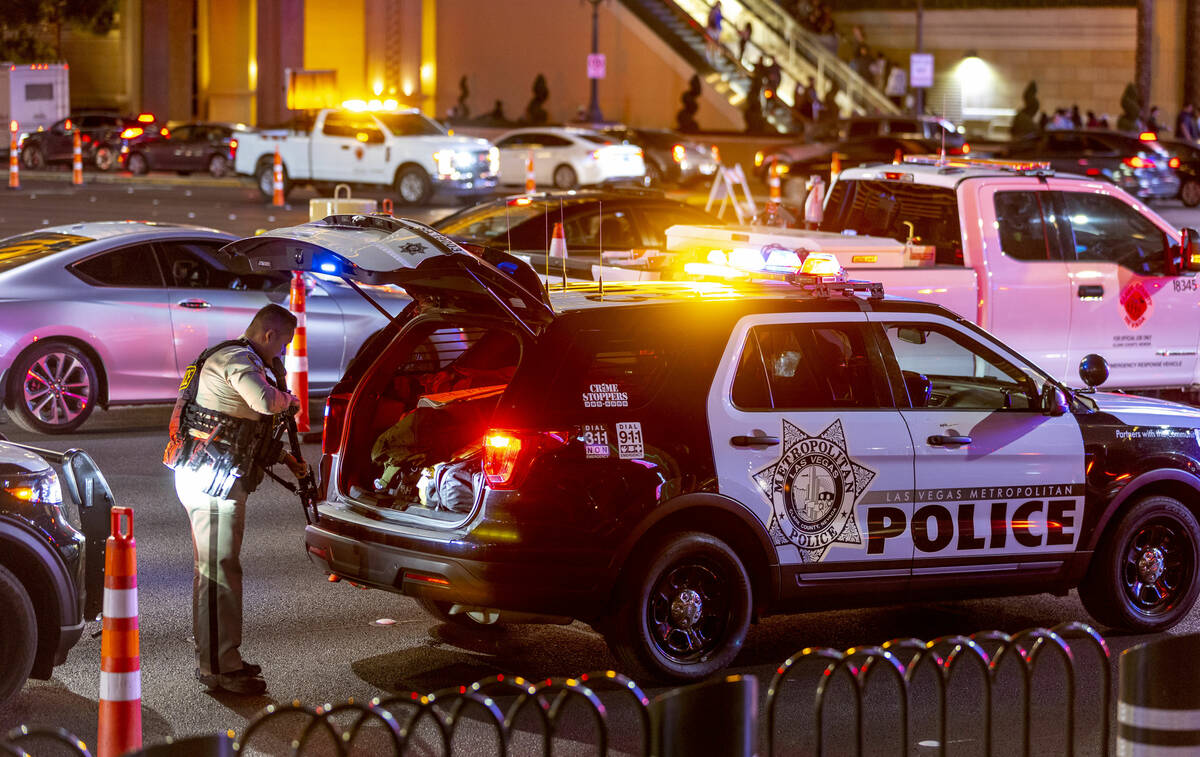A Las Vegas police officer readies a weapon while setting up for New Year’s Eve crowds along ...
