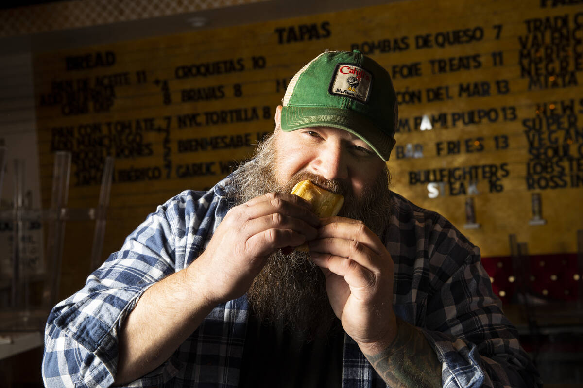Ralph Perrazzo, founder of Snap-O-Razzo, eats a Snap-O-Razzo hot dog on Tuesday, April 5, 2022, ...
