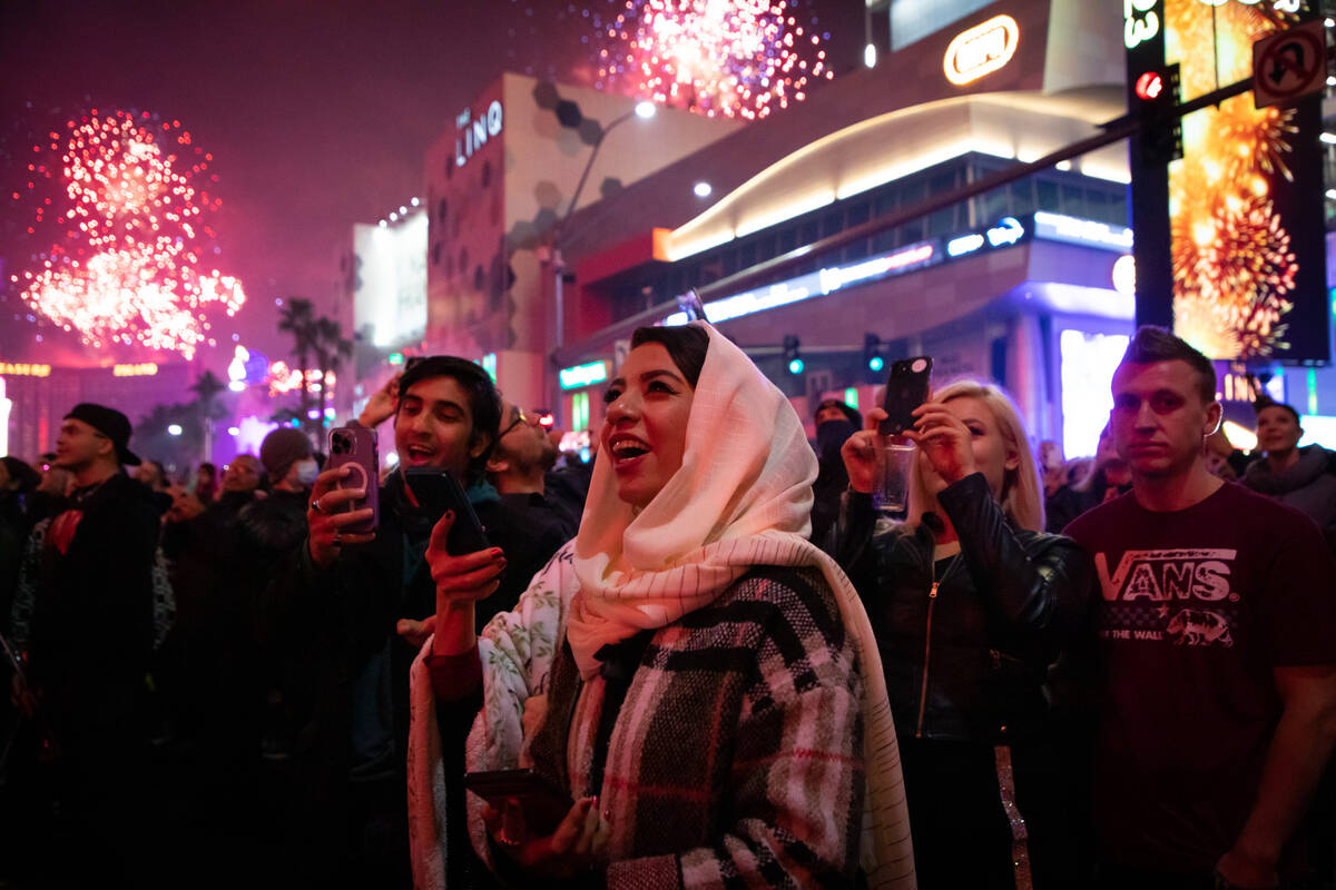 New Year’s Eve revelers watch the fireworks on the Strip on Saturday, Dec. 31, 2022. (Am ...