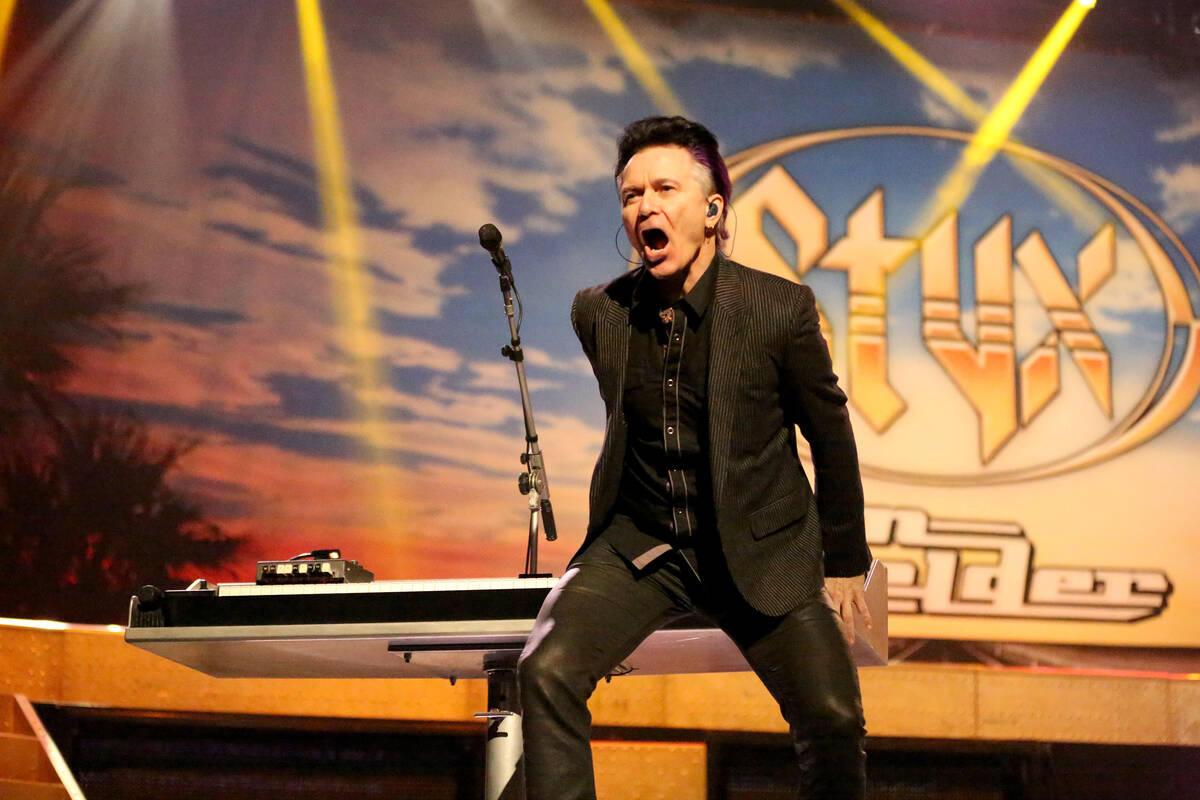 Lawrence Gowan of Styx plays the keyboard behind his back during a performance of the Styx hit, ...