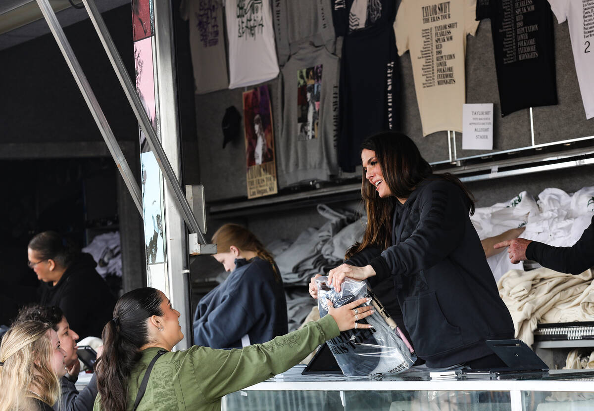 A fan buys Taylor Swift merchandise at a pop-up store outside Allegiant Stadium in Las Vegas, T ...