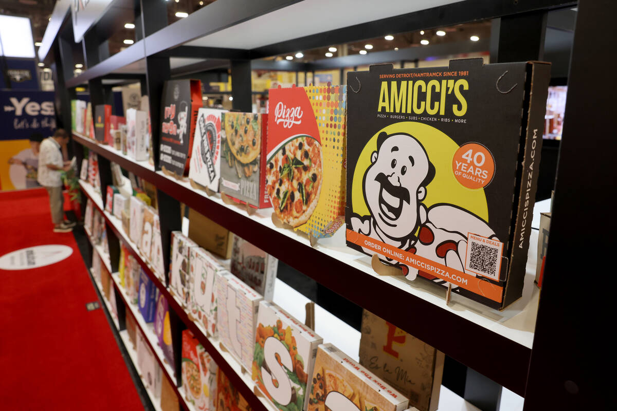 Conventioneers check out pizza boxes on display at the Ankutsan Packaging booth at the Internat ...