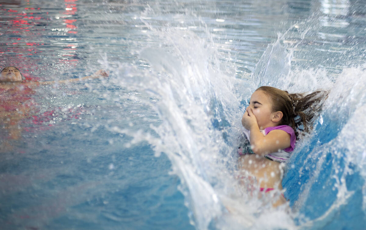 Ashleigh Casillas, 9, right, cannonballs into the water as Julia Urquieta, 8, left, floats at H ...