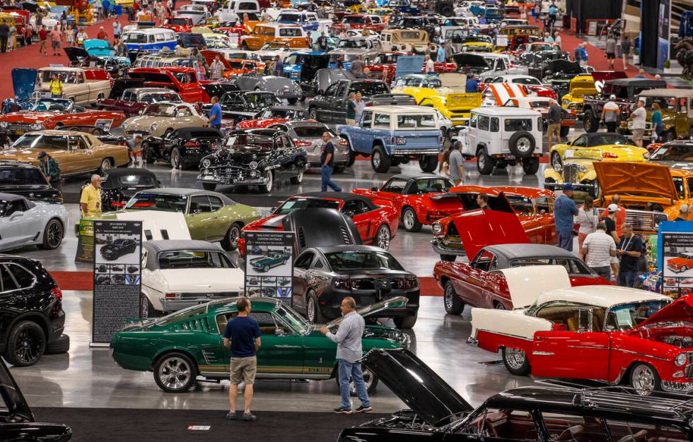 Attendees walk about some of the numerous cars already sold and still up for bid during the Bar ...