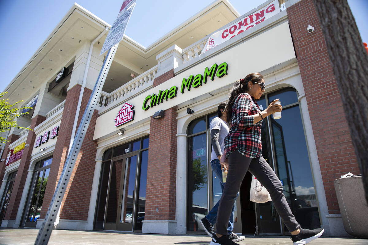 People walk in front of the new location for China Mama in Shanghai Plaza in Chinatown, where t ...