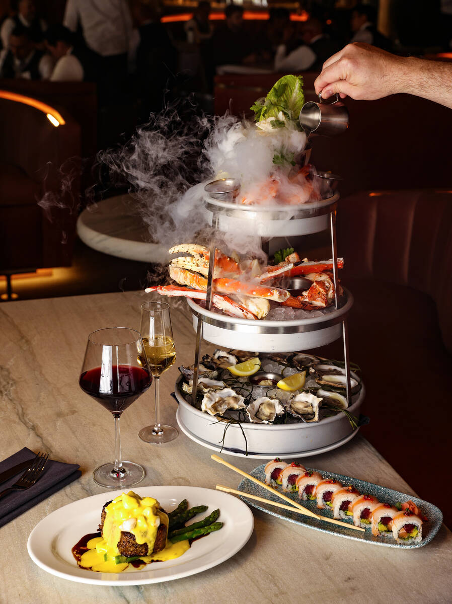 Corporate Chef Ian Rough pours water into the dry ice component of the Smoking Shellfish Tower, ...