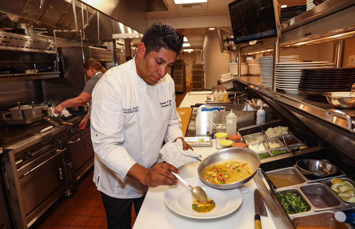 Executive Chef Eugenio Reyes plates the Alaskan Halibut at Ocean Prime, an upscale seafood and ...