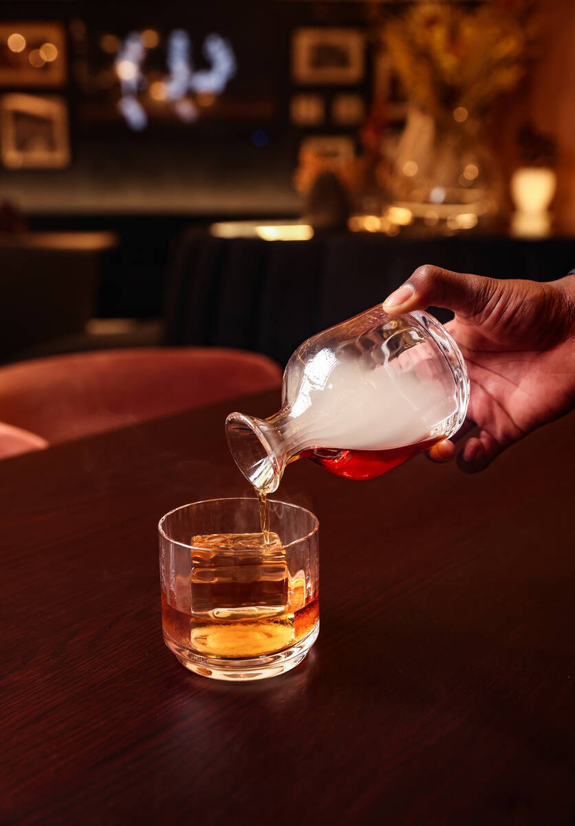 Beverage Operations Manager Josh Dunson pours smoke into the Old Fashioned, made of Uncle Neare ...