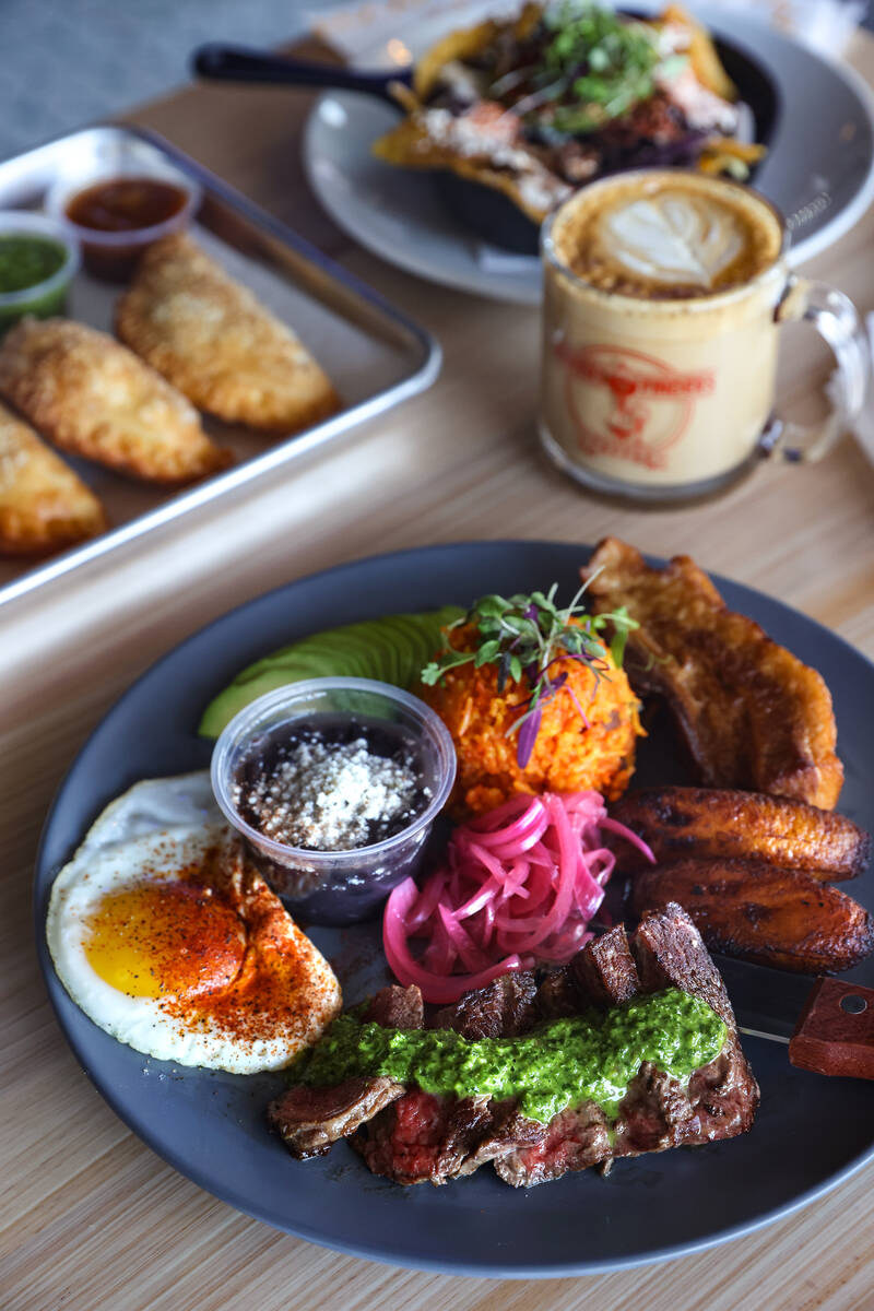 The bandeja paisa, made of eight ounces flat iron steak, crispy pork belly, fried maduros, a su ...