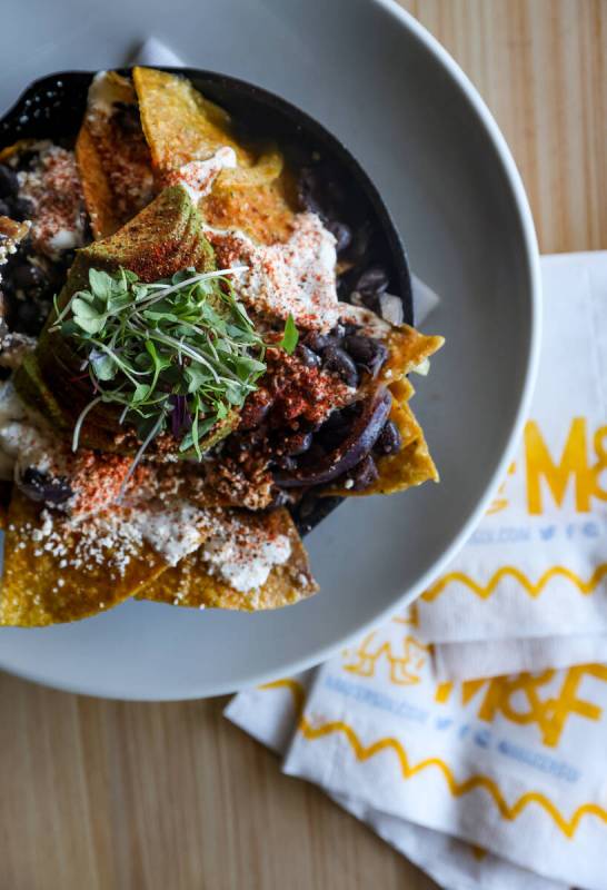 Chilaquiles, made with salsa verde, tortilla chips, folded egg, black beans, onion and jalapeñ ...