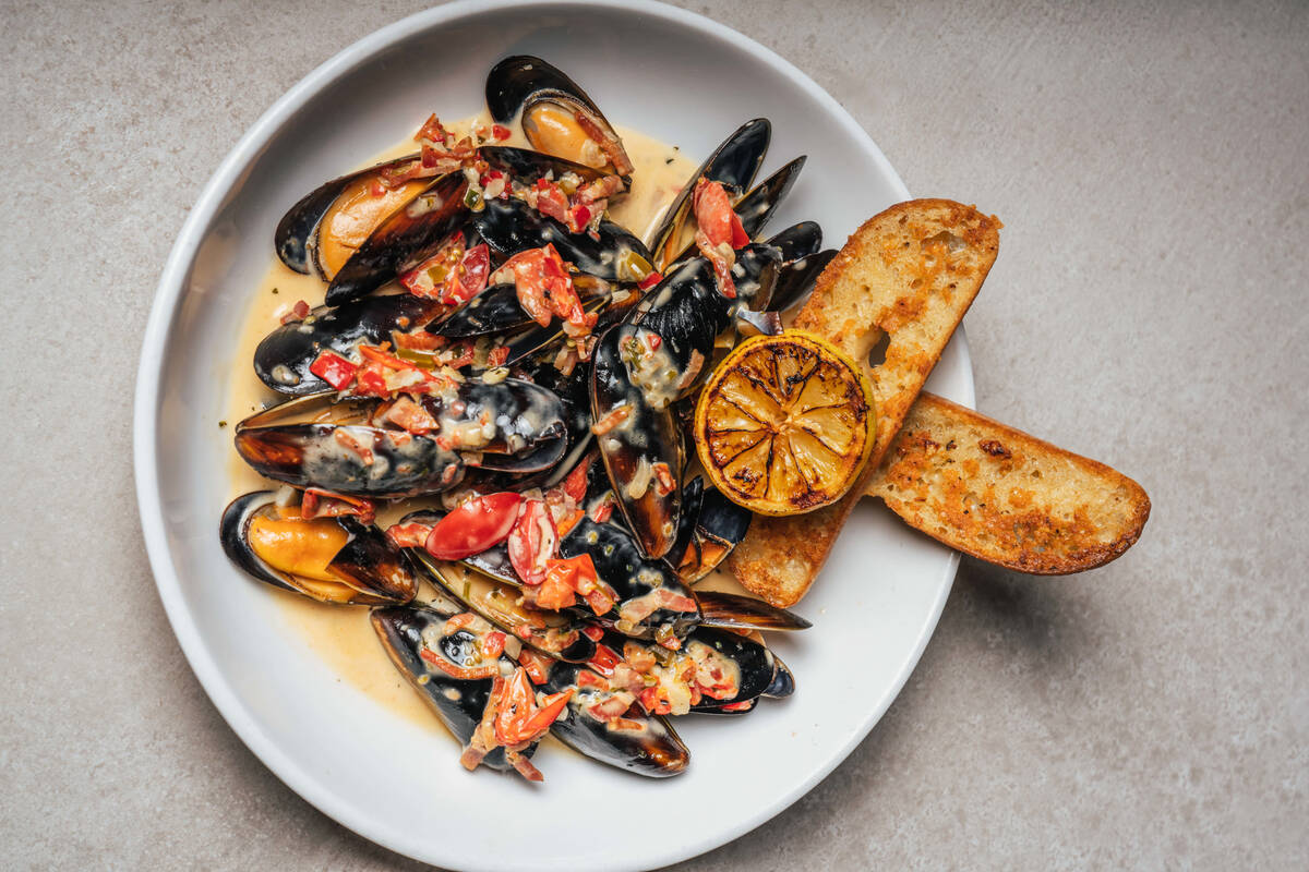 Prince Edward Island mussels in white wine cream sauce, with bacon, tomatoes, lemon and focacci ...