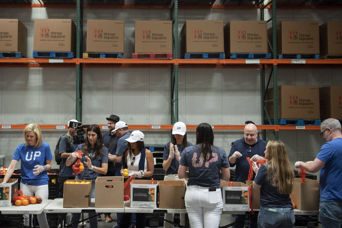 Volunteers pack bags of fruit to be distributed to seniors at Three Square food bank on Wednesd ...