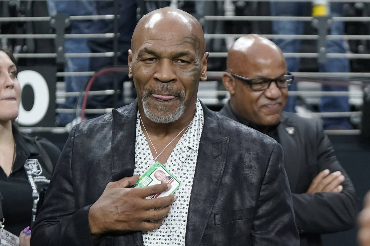 Former heavyweight boxing champion Mike Tyson stands on the field before an NFL football game b ...