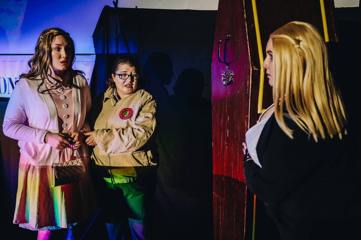 Actors act out “Rocky Horror Picture Show” underneath a screen showing the movie ...
