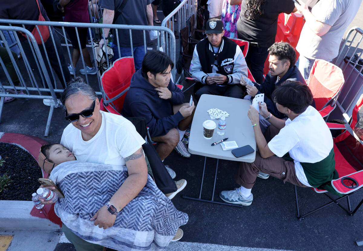 Fani Leilua holds her grandson Legend Leilua 2, at the front of the line for the grand opening ...